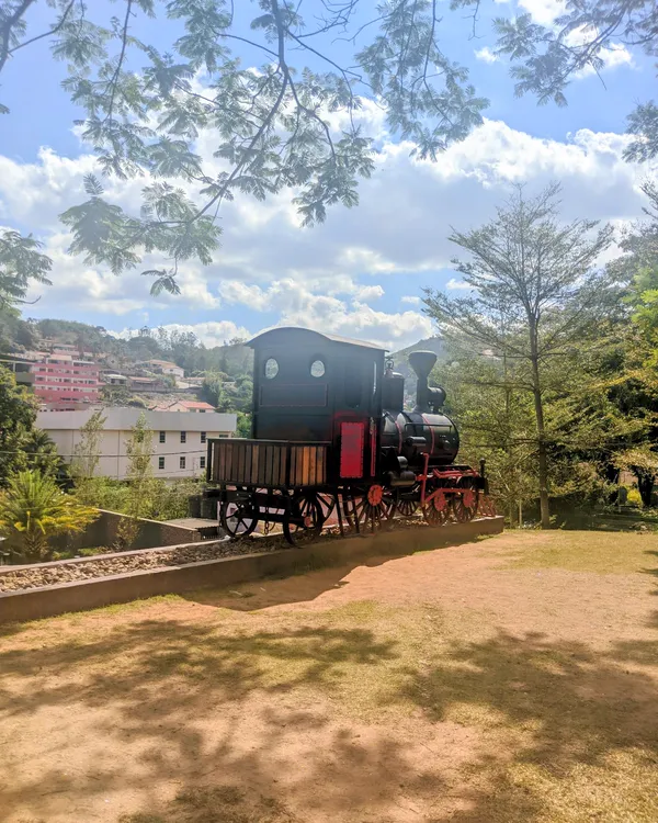 Locomotiva antiga exposta em praça arborizada