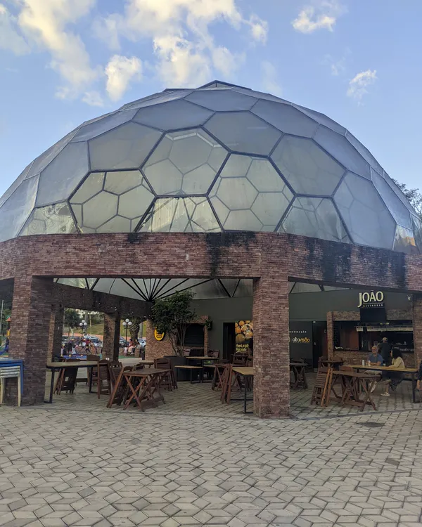 Café com cúpula de vidro e mesas na varanda