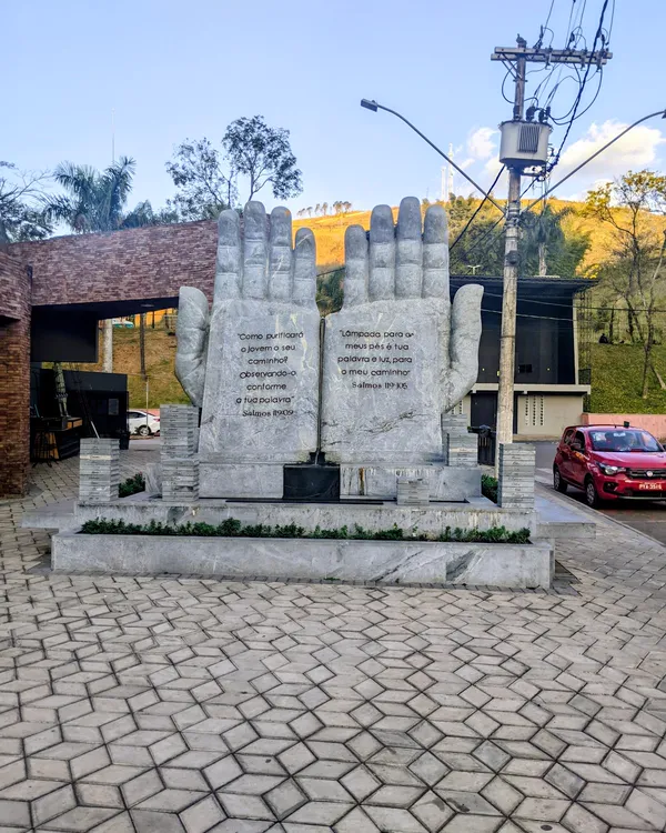 Monumento de mãos esculpidas em pedra, na praça