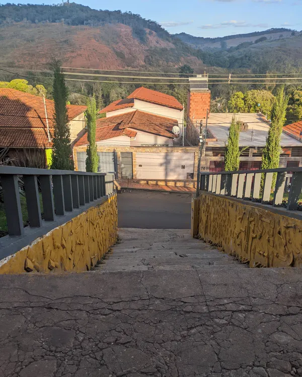 Rua com casas de telhado colonial e a serra ao fundo