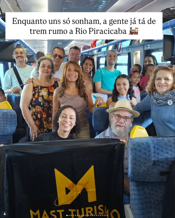 Grupo de turistas sorrindo dentro do trem, a caminho de Rio Piracicaba