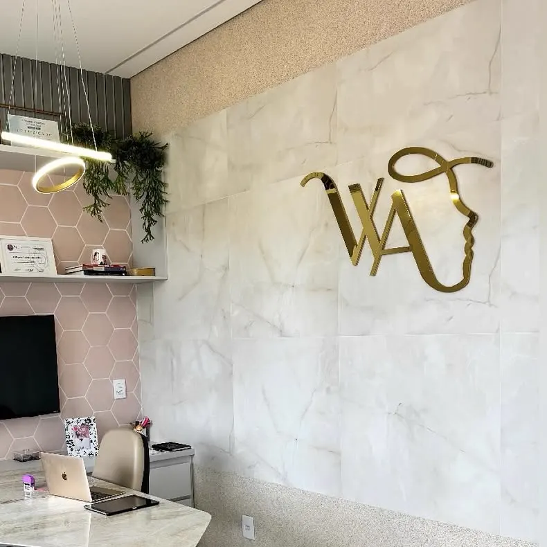 Sala de avaliação com o logotipo dourado na parede de mármore