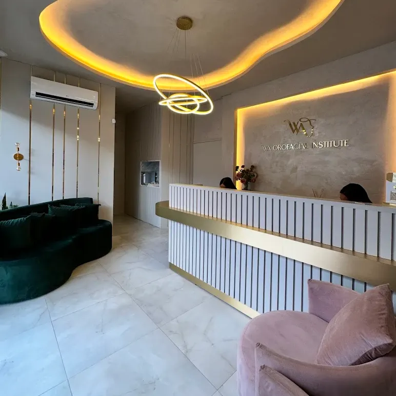 Recepção com o balcão dourado e o lustre de anéis