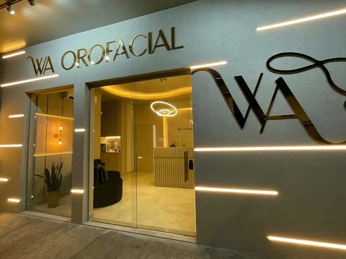 Fachada da WA Orofacial vista da rua, com o letreiro dourado e a porta de vidro