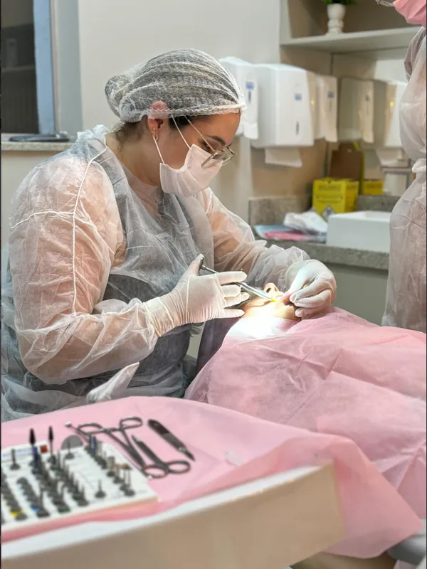 Dentista da WA em procedimento, com os instrumentos sobre a bancada