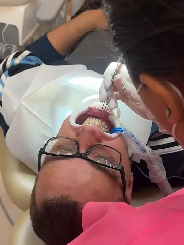 Dentista atendendo um paciente na cadeira odontológica